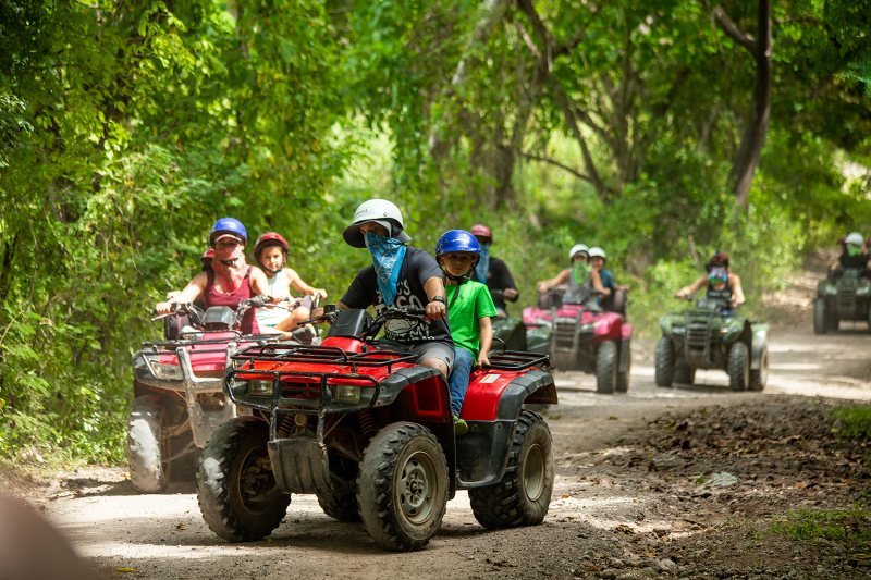 Family riding ATVs together on the Río Cuale jungle trail