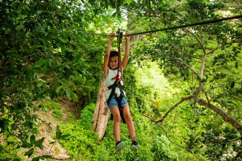 Zipline rider crossing the jungle canopy at Rancho Capomo, Puerto Vallarta